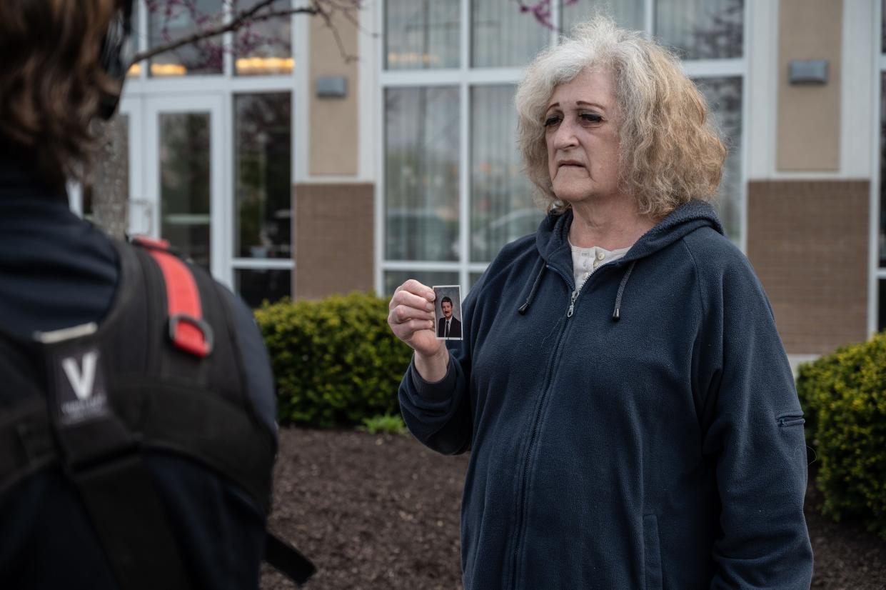 Mary Carol Weisert displays a picture of her husband, John Weisert, near his workplace at a FedEx ground facility in Indianapolis on Friday. Weisert says she does not know what happened to her husband.