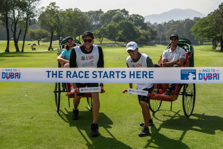 Tommy Fleetwood of England (back L) and Rafa Cabrera Bello of Spain (back R) take part in a photo call during the launch of the 'Road to Dubai', ahead of the Hong Kong Open golf tournament, at the Hong Kong Golf Club, on November 22, 2017