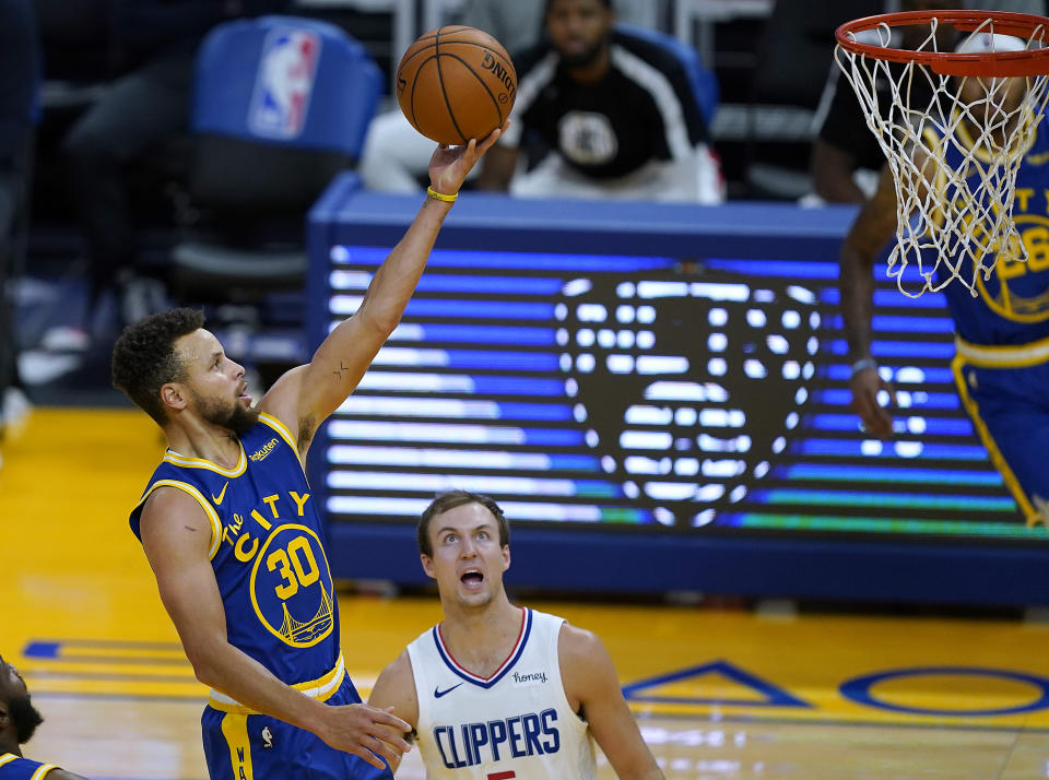 Golden State Warriors guard Stephen Curry (30) drives with the ball past Los Angeles Clippers guard Luke Kennard during the second half of an NBA basketball game in San Francisco, Friday, Jan. 8, 2021. (AP Photo/Tony Avelar)