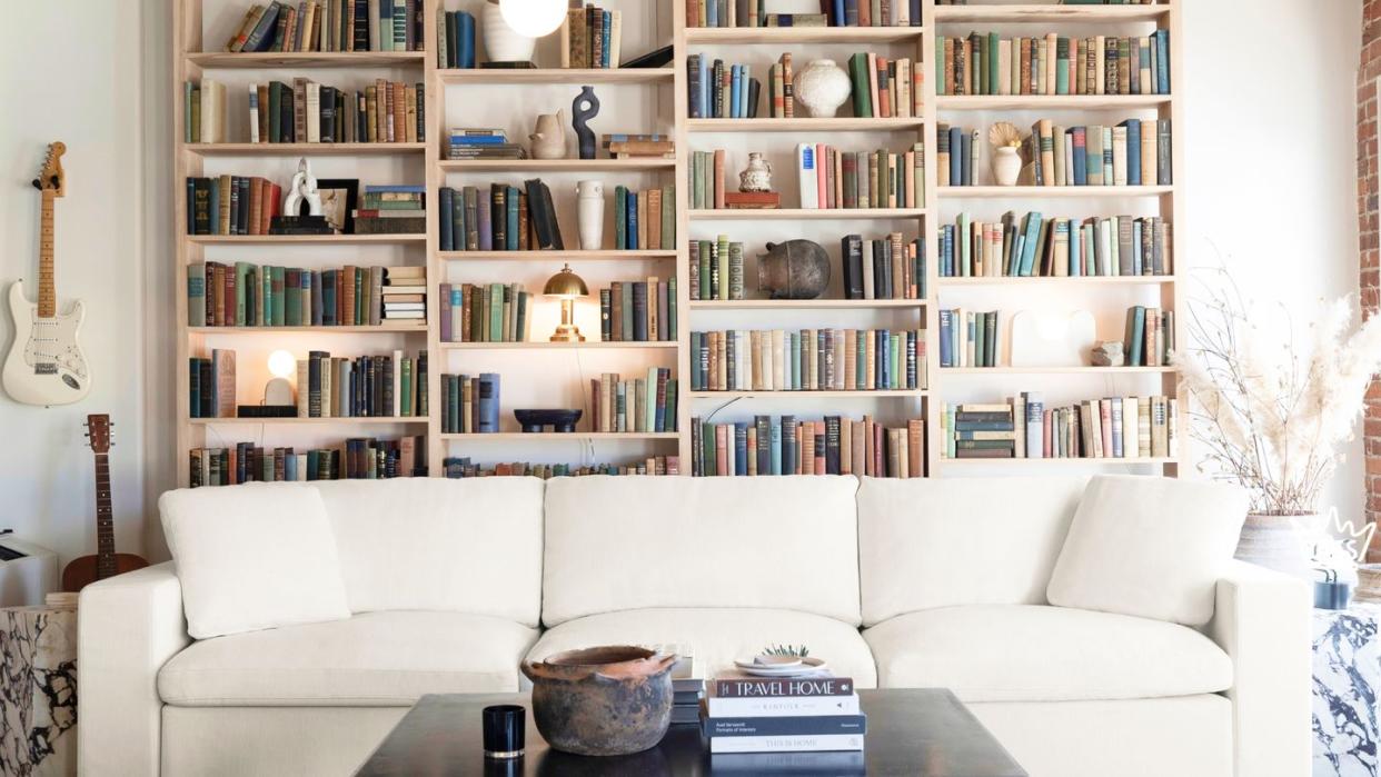 a white couch in front of a bookcase