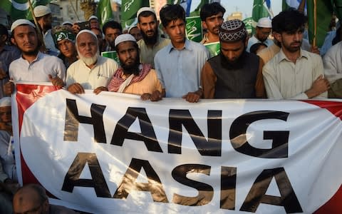 Pakistani supporters of Jamaat-e-Islami (JI), a religious political party, chant slogans and gestures while waving the party falg during a protest following the Supreme Court decision to acquit Christian woman Asia Bibi of blasphemy, in Karachi on November 4, 2018 - Credit: AFP