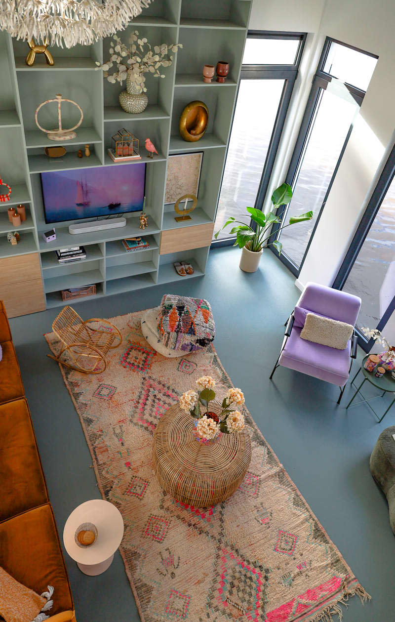 Living room with sky blue wall unit seen from balcony.