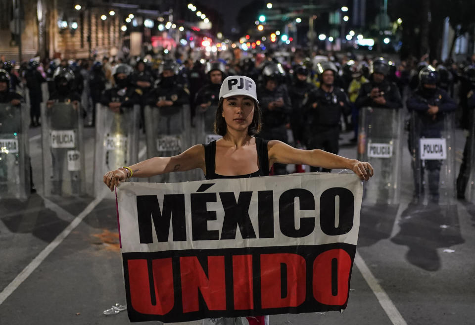 Student Daniela Camberos shows a banner in front of the police during a protest against government's proposed judicial reform, which would make judges stand for election, outside the Senate in Mexico City, Tuesday, Sept. 10, 2024. (AP Photo/Felix Marquez)