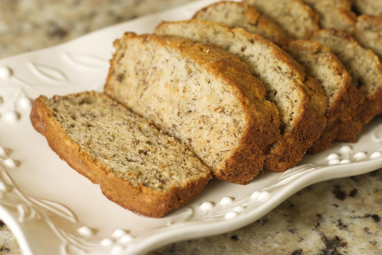 Sliced banana bread on a platter. Shallow DOF.  Focus on front end of loaf.