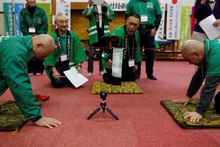 Members of the Bald Men Club, take part in a unique game of tug-of-war by attaching suction pads onto their heads, at a hot spring facility in Tsuruta town, Aomori prefecture, Japan, February 22, 2017. REUTERS/Megumi Lim