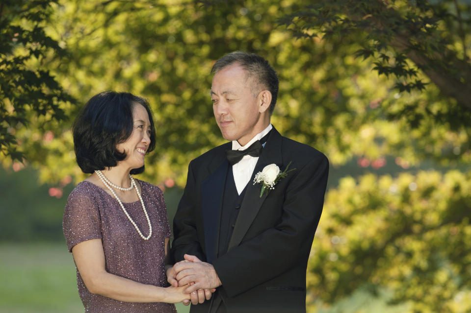 A couple holding hands at their wedding