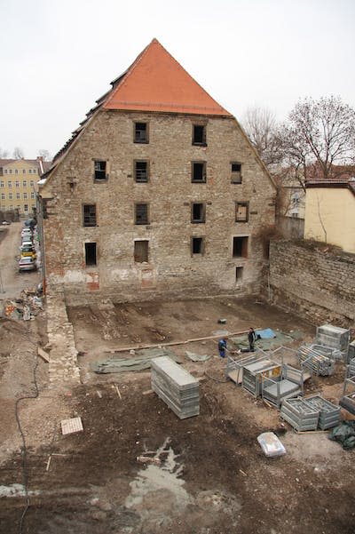 Archaeologists worked to recover medieval remains from a graveyard. The granary building is in the background. Thuringian State Office for Heritage Management and Archaeology/Martin Sowa, <a href="http://creativecommons.org/licenses/by-nd/4.0/" rel="nofollow noopener" target="_blank" data-ylk="slk:CC BY-ND;elm:context_link;itc:0;sec:content-canvas" class="link ">CC BY-ND</a>