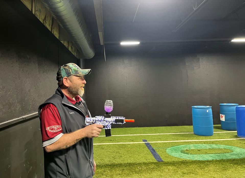 Larry Miller, the manager of Lebanon Indoor Archery and Supplies shows off a splat gun in the stores new battle room. Feb. 24