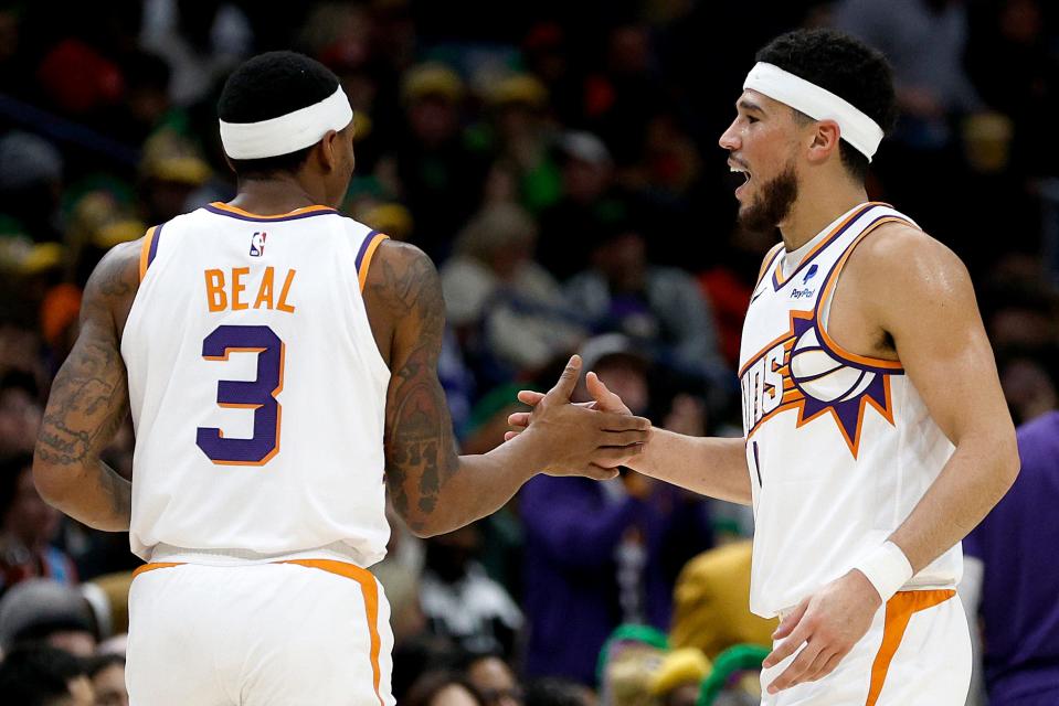 Devin Booker #1 of the Phoenix Suns and Bradley Beal #3 of the Phoenix Suns react after scoring against the New Orleans Pelicans during the second quarter of an NBA game at Smoothie King Center on Jan. 19, 2024, in New Orleans, Louisiana.