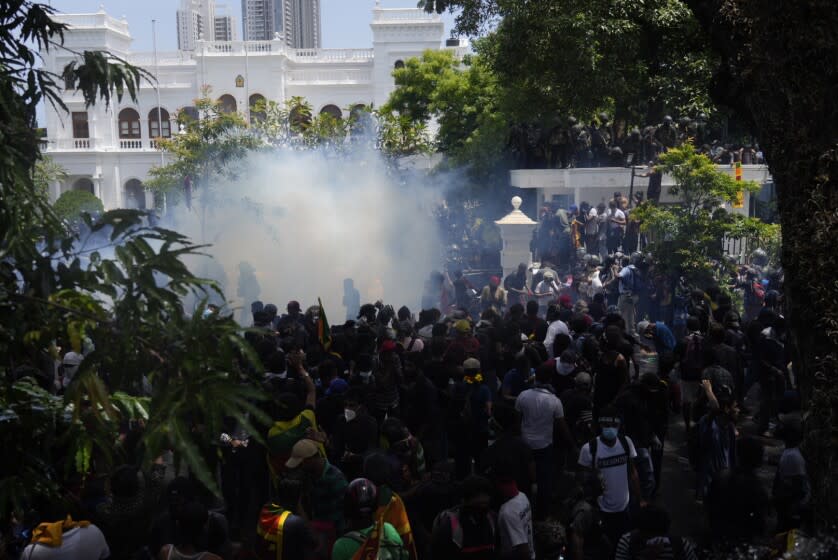 Police use teargas as Sri Lankan protesters storm prime minister Ranil Wickremesinghe 's office, demanding he resign after president Gotabaya Rajapaksa fled amid economic crisis in Colombo, Sri Lanka, Wednesday, July 13, 2022. (AP Photo/Rafiq Maqbool)