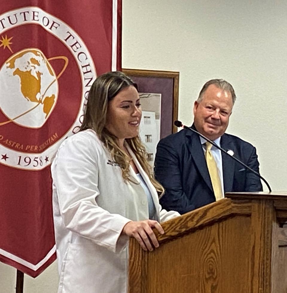 Anna Struhar, a Melbourne native and fourth-year student at Burrell College of Osteopathic Medicine, speaks during Thursday's event as  John Hummer, Burrell College president and co-founder, listens in.