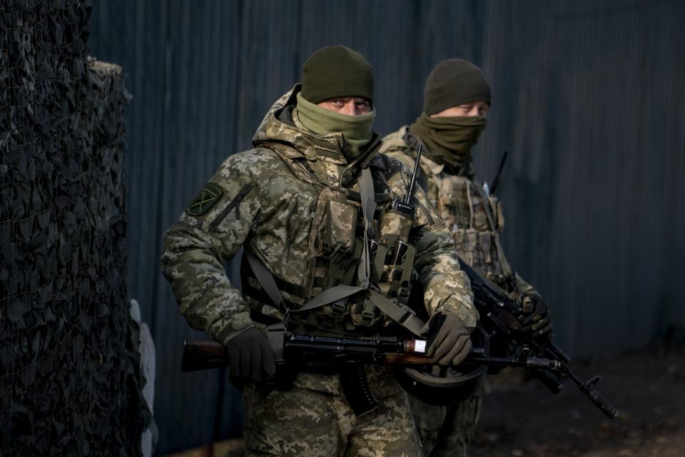 FILE In this file photo taken on Saturday, Nov. 2, 2019, Ukrainian servicemen guard a checkpoint near the new line of contact in Zolote, Luhansk region, eastern Ukraine. Ukraine's president sits down Monday, Dec. 9, 2019 for peace talks in Paris with Russian President Vladimir Putin in their first face-to-face meeting, and the stakes could not be higher. More than five years of fighting in eastern Ukraine between government troops and Moscow-backed separatists has killed more than 14,000 people, and a cease-fire has remained elusive. (AP Photo/Evgeniy Maloletka, File)