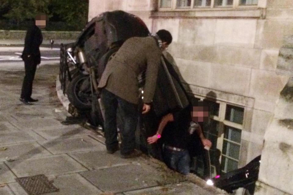 A man believed to be the driver clambers free from the crashed vehicle (Evening Standard)