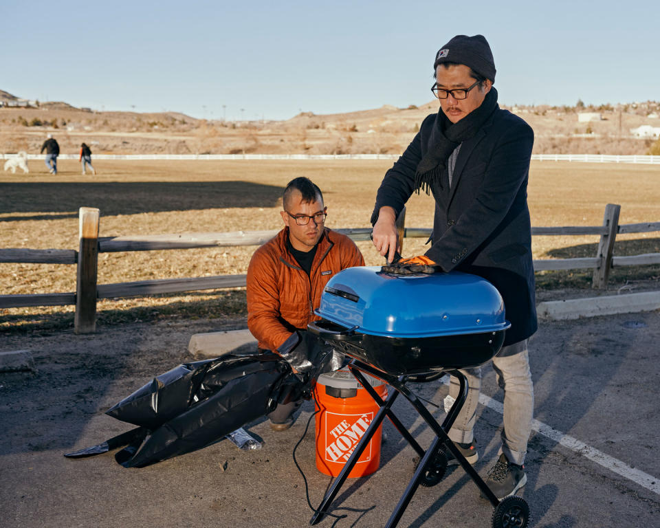 Luke Iseman and Andrew Song use a grill to burn sulfur powder and capture the smoke in a plastic bag.<span class="copyright">Balazs Gardi for TIME</span>