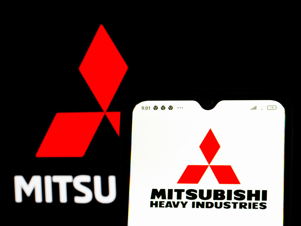 UKRAINE - 2022/02/02: In this photo illustration, the Mitsubishi Heavy Industries logo is displayed on a smartphone screen with a Mitsubishi Corporation logo in the background. (Photo Illustration by Igor Golovniov/SOPA Images/LightRocket via Getty Images)