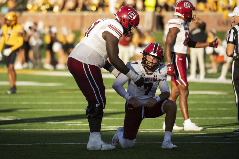 South Carolina quarterback Spencer Rattler, right, is helped off the turf by teammate Tree Babalade, left, after he was sacked during the fourth quarter of an NCAA college football game Saturday, Oct. 21, 2023, in Columbia, Mo. Missouri won 34-12. (AP Photo/L.G. Patterson)