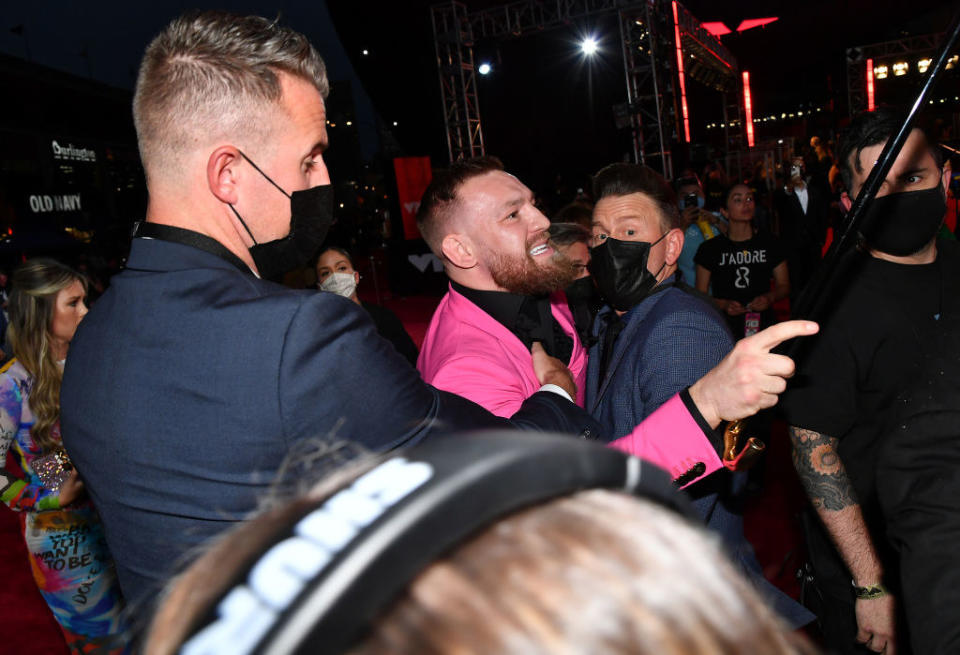 Conor being held back by security