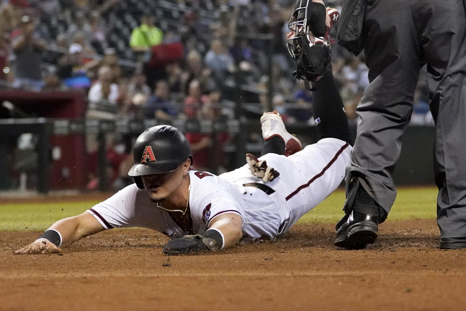 Arizona Diamondbacks' Josh Rojas scores on a double by Ketel Marte against Atlanta Braves during the third inning of a baseball game, Monday, Sept. 20, 2021, in Phoenix. (AP Photo/Matt York)