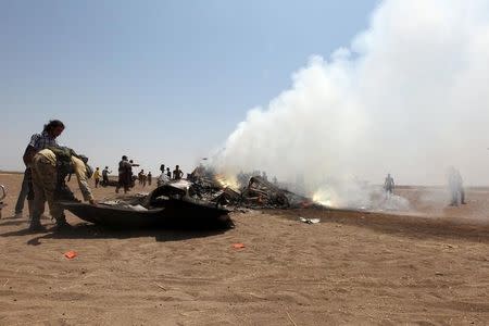 Rebel fighters and civilians inspect the wreckage of a Russian helicopter that had been shot down in the north of Syria's rebel-held Idlib province, Syria August 1, 2016. REUTERS/Ammar Abdullah