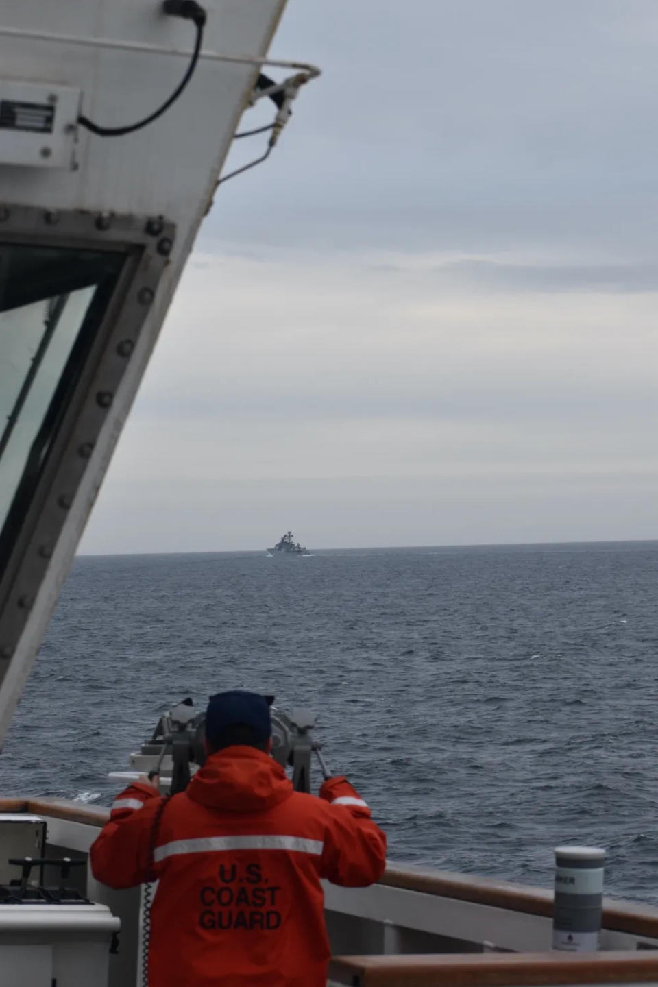 A Coast Guard Cutter Kimball crewmember observes a People's Republic of China Guided Missile Cruiser about 75 nautical miles north of Kiska Island Alaska on Sept. 19, 2022.