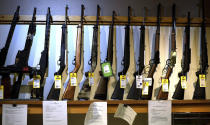 In this March 28, 2020 photo, rifles are offered for sale at Center Target Sports in Post Falls, Idaho. Far-right politicians across the U.S. are warning that state governments are using the coronavirus pandemic to trample on civil liberties. They are railing against efforts by state government leaders to close churches and gun stores and to prevent large public gatherings. (Kathy Plonka/The Spokesman-Review via AP)