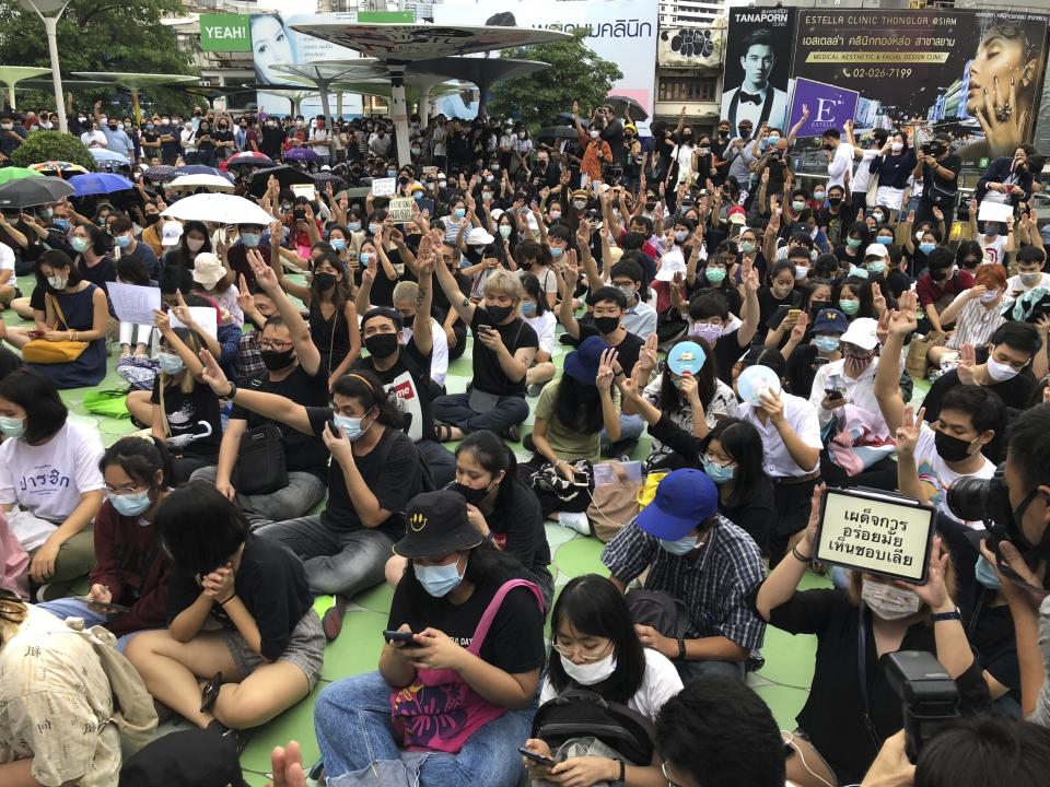 Protesters raise their hands with a three-fingered salute as a symbol of resistance during an anti-government gathering attended by hundreds of people Saturday, Aug. 8, 2020, in Bangkok, Thailand. Political tensions are rising in Thailand as pro-democracy activists vowed to step up protests against the government and police arrested some key figures in recent demonstrations. (AP Photo/Jerry Harmer)