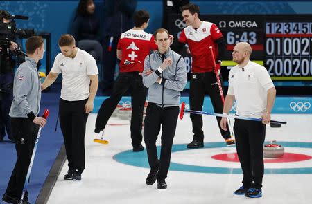 Curling - Pyeongchang 2018 Winter Olympics - Men’s Tie-Breaker - Switzerland v Britain - Gangneung Curling Center - Gangneung, South Korea - February 22, 2018 - Kyle Smith of Britain reacts with team mates Thomas Muirhead, Kyle Waddell and Cameron Smith as Benoit Schwarz and Peter de Cruz of Switzerland celebrate in the background. REUTERS/Cathal McNaughton