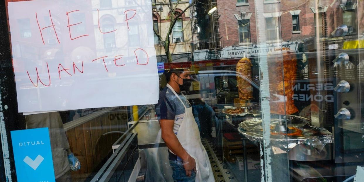 A "help wanted" sign in a restaurant window