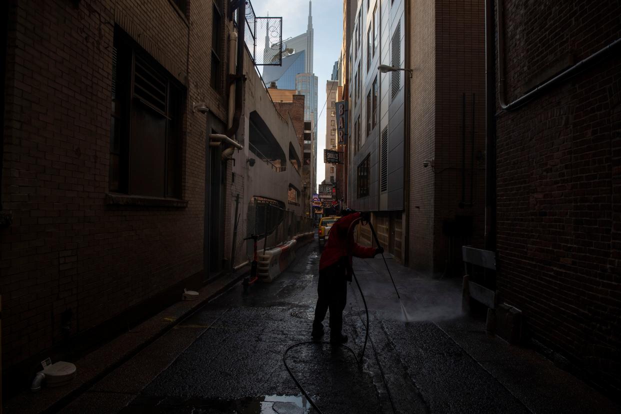 arold Bingham uses a pressure hose to clean a spot near Printers Alley in Nashville on Nov. 13.