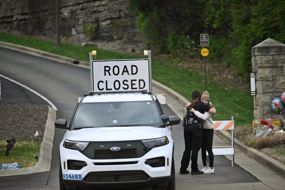 A woman hugs a police officer at the entrance of the Covenant School in Nashville, Tenn., on March 28, 2023. (Brendan Smialowski / AFP - Getty Images)