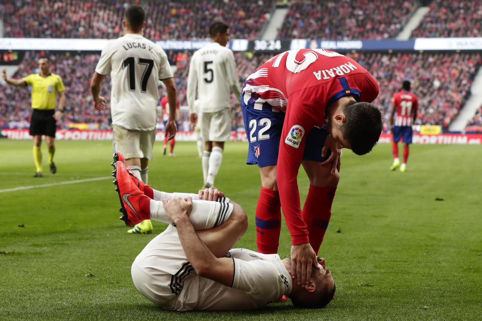 Álvaro Morata (derecha) del Atlético de Madrid constata si Dani Carvajal del Real Madrid está bien durante el partido de la Liga española en el estadio Wanda Metropolitano en Madrid, el sábado 9 de febrero de 2019. (AP Foto/Manu Fernández)