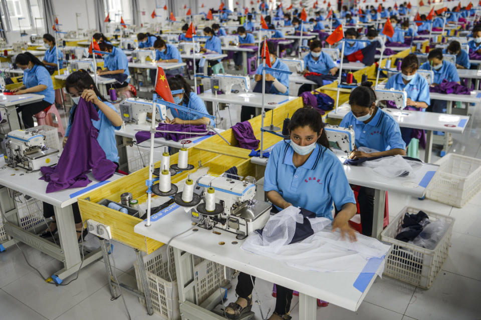 2020年6月18日中國新疆維吾爾自治區，工人戴着口罩在一家服裝廠工作。