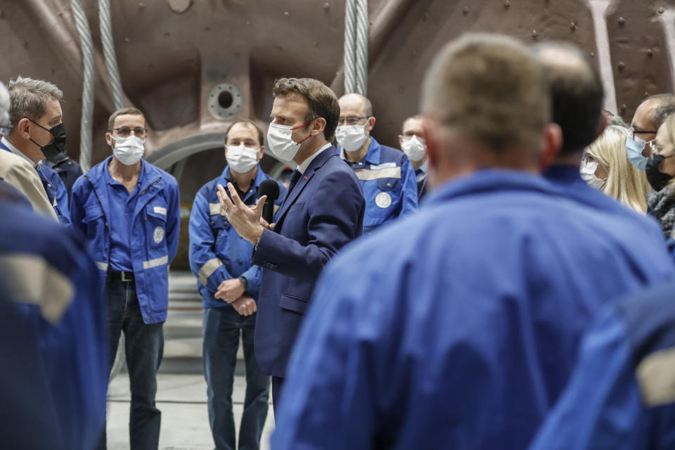 French President Emmanuel Macron talks to officials and workers as he visits the GE Steam Power System main production site for its nuclear turbine systems in Belfort, eastern France, Thursday, Feb. 10, 2022. French President Emmanuel Macron is to unveil plans to build new nuclear reactors in the country as part of its energy strategy to reduce planet-warming emissions. (AP Photo/Jean-Francois Badias, Pool)