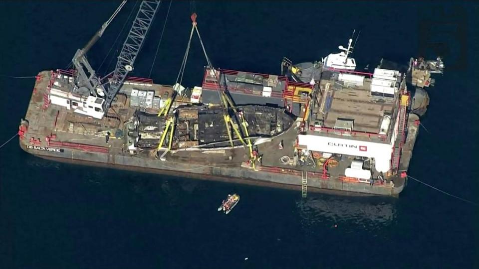 This image from aerial video provided by KTLA-TV shows the burned hulk of the Conception diving boat being brought to the surface by the Curtin Maritime’s manned Derrick Barge Salta Verde and its salvage team off Santa Cruz Island on Thursday.