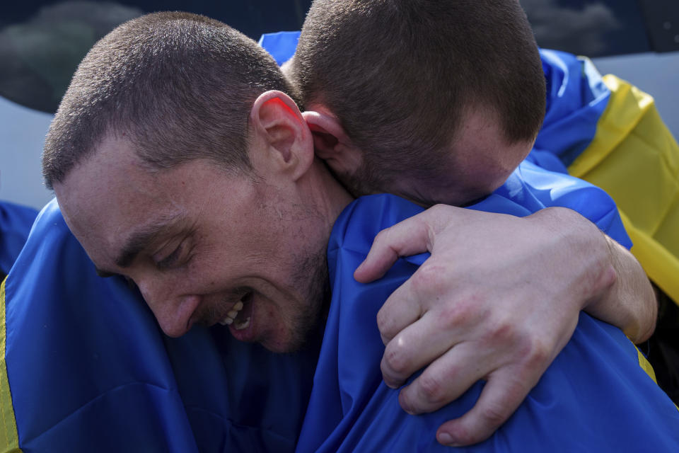 A Ukrainian serviceman hugs his comrade after returning from captivity during POWs exchange in Sumy region, Ukraine, Friday, May 31, 2024. Ukraine returned 75 prisoners, including four civilians, in the latest exchange of POWs with Russia. It's the fourth prisoner swap this year, and 52nd since Russia invaded Ukraine. In all, 3 210 Ukrainian servicemen and civilians were returned since the outbreak of the war. (AP Photo/Evgeniy Maloletka)