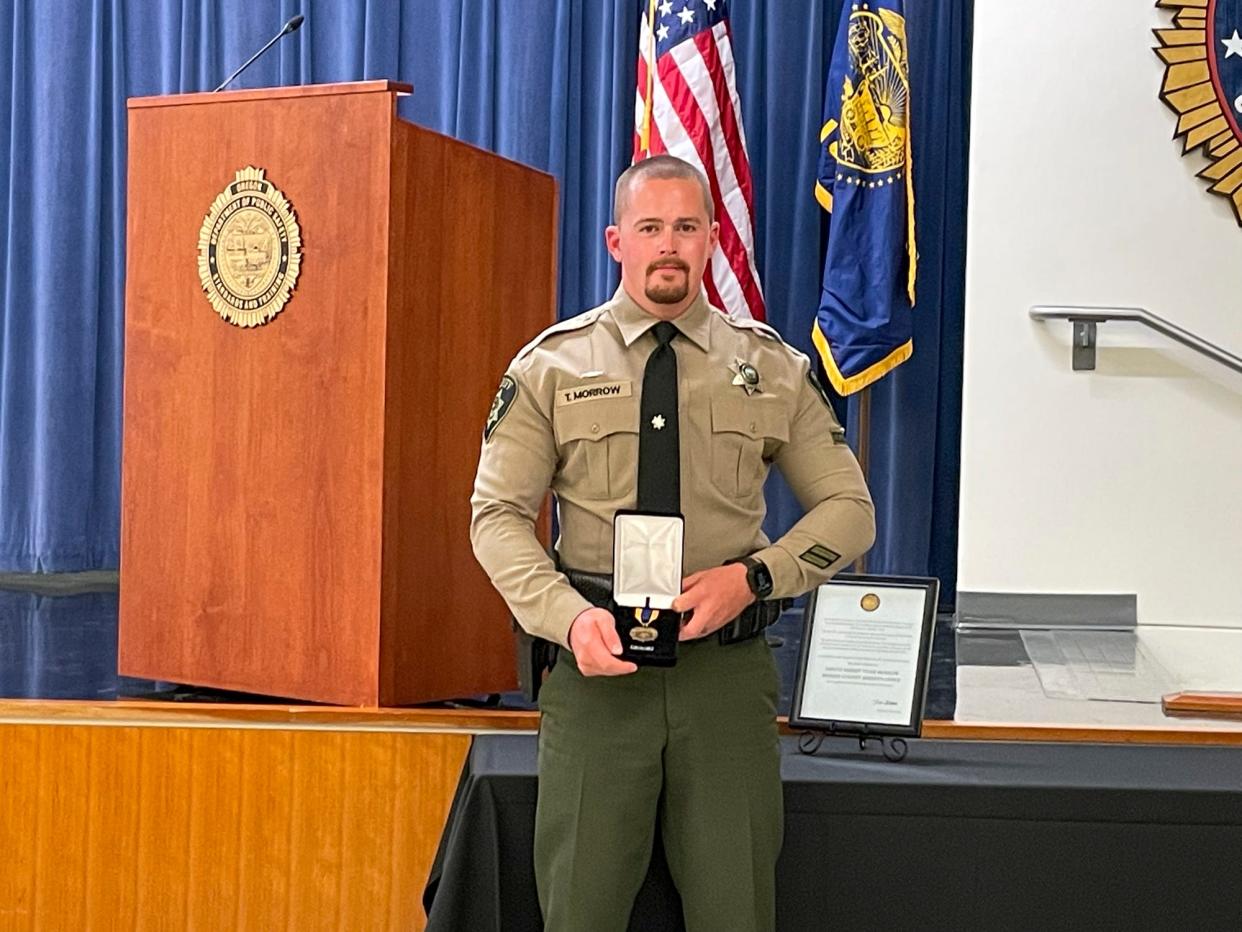 Deputy Sheriff Tyler Morrow of the Marion County Sheriff's Office holds the Law Enforcement Medal of Honor during a ceremony held at the Oregon Public Safety Academy in Salem. Morrow is the second law enforcement officer ever awarded the honor.