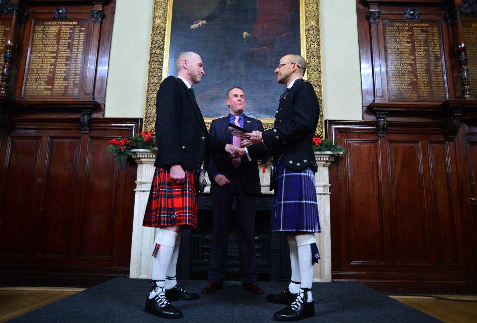 GLASGOW, SCOTLAND - DECEMBER 31: A couple of the same sex Joe Schofield (blue kilt) and Malcolm Brown from Tullibody, Clackmannanshire are married by Ross Wright, Celebrant from Humanist Society Scotland in the Trades Hall shortly after midnight in front of friends and family in one of the first same-sex and belief category weddings in Scotland on December 31, 2014 in Glasgow, Scotland. Same-sex couples have been able to enter into 'civil partnerships' since 2005, however following a change in the law on February 4, 2014. A couple of the same sex are now eligible to marry in Scotland. Parliament's decision to grant same-sex couples an equal right to marriage has been met with opposition from religious groups. Gay marriage is already legal in England and Wales, however the Northern Ireland administration has no plans to make it law. (Photo by Mark Runnacles/Getty Images)