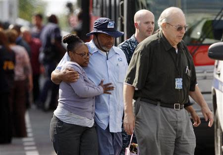 Navy Yard workers evacuated after the shooting are reunited with loved ones at a makeshift Red Cross shelter at the Nationals Park baseball stadium near the affected naval installation in Washington, September 16, 2013. REUTERS/Jonathan Ernst