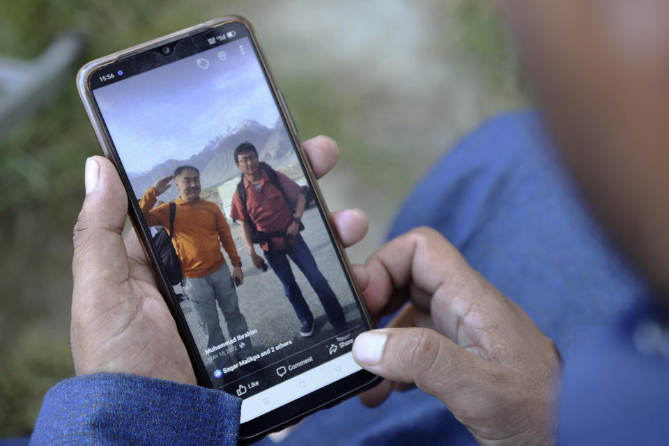 Pakistani guide Muhammad Ibrahim shows a picture of Japanese climbers, Semba Takayasu with Shinji Tamura, who was died during summiting highest and unscaled peaks, in his mobile, in Skardu, Pakistan, Tuesday, Aug. 15, 2023. Japanese climber Shinji Tamura died, and his fellow mountaineer Semba Takayasu was injured while trying to scale one of the highest and unscaled peaks in northern Pakistan last week, a mountaineering official and the injured climber said on Tuesday. (AP Photo/M.H. Balti)