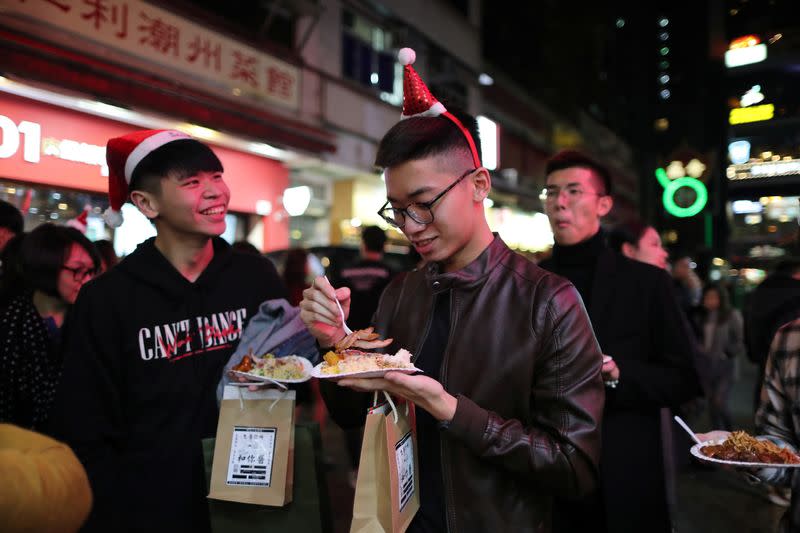 Protesters queue for a free Christmas dinner offered by a local restaurant in Hong Kong