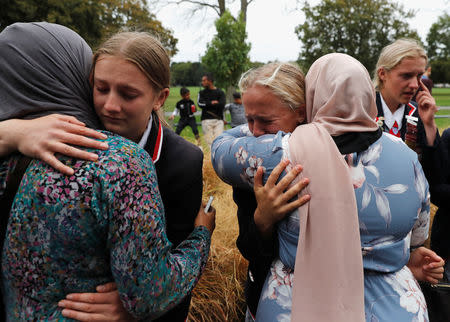 High school students from a Christian school embrace as they give hugs to Muslims waiting for news of their relatives at a community centre, following Friday's shooting in Christchurch, New Zealand March 18, 2019. REUTERS/Jorge Silva