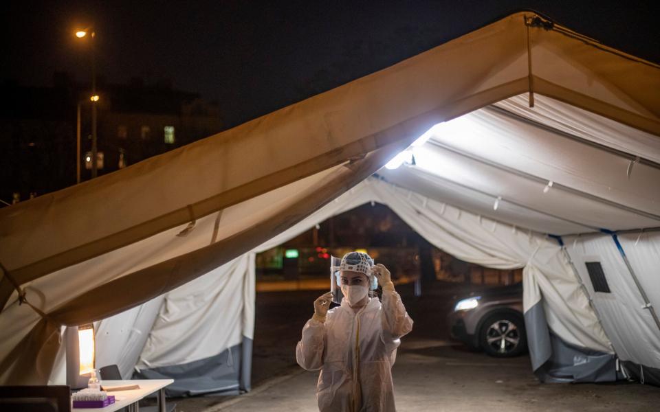 A medical worker wearing personal protective equipment (PPE) adjusts her shield at drive-in coronavirus testing station in Prague, Czech Republic - MARTIN DIVISEK/EPA-EFE/Shutterstock