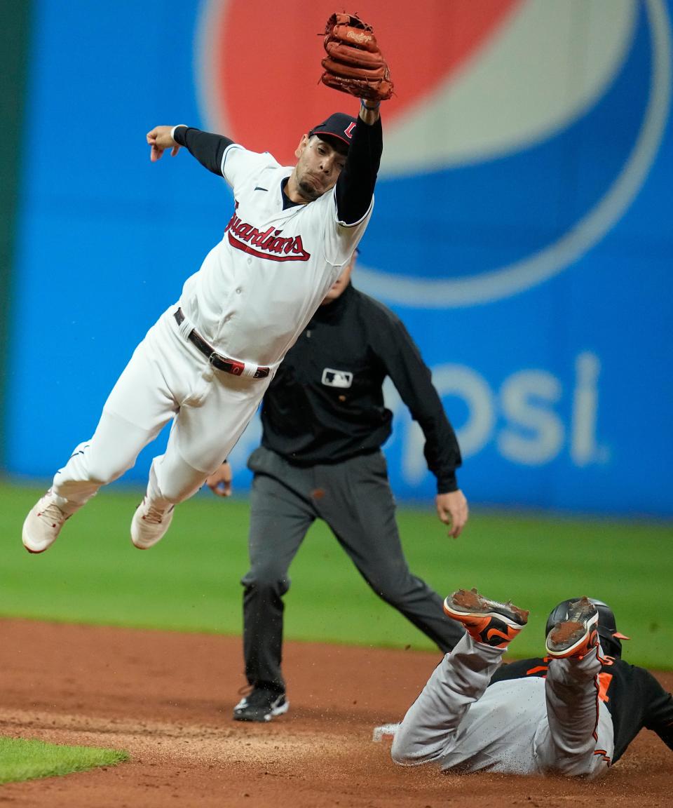 Baltimore Orioles' Aaron Hicks steals second base as Cleveland Guardians second baseman Andrés Giménez is pulled off the bag as he reaches for the throw in the sixth inning of a baseball game Friday, Sept. 22, 2023, in Cleveland. (AP Photo/Sue Ogrocki)