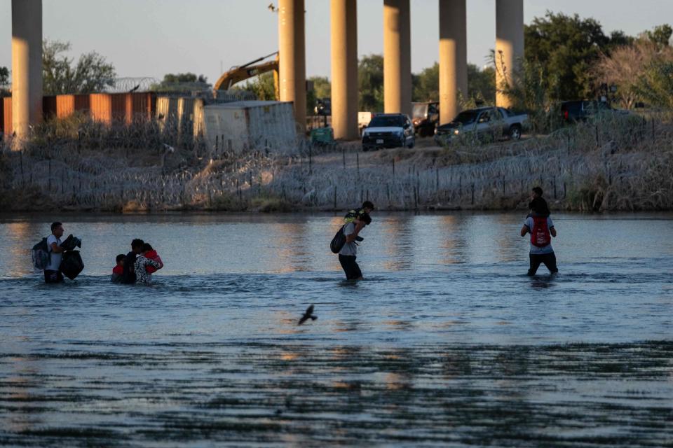 Migrants cross the Rio Grande into the United States in on Aug. 4 in Eagle Pass, Texas, as seen from Piedras Negras, Coahuila state, Mexico.