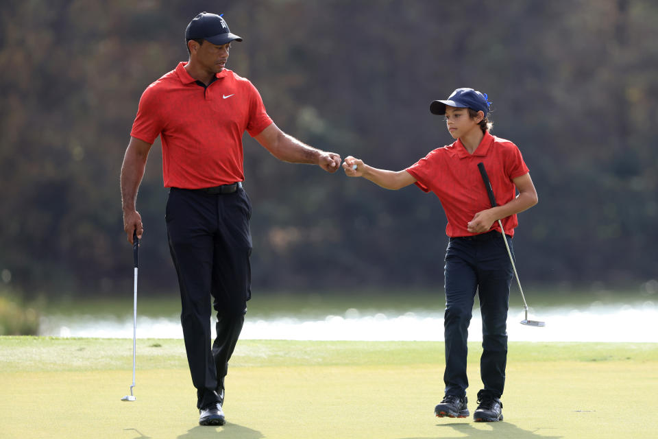 ORLANDO, FLORIDA - DECEMBER 19: Tiger Woods and Charlie Woods celebrate a birdie on the 13th hole during the final round of the PNC Championship at the Ritz Carlton Golf Club Grande Lakes   on December 19, 2021 in Orlando, Florida. (Photo by Sam Greenwood/Getty Images)