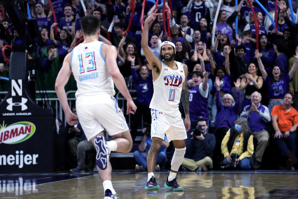 Northwestern guard Boo Buie, right, celebrates with guard Brooks Barnhizer after making a 3-pointer against Illinois during overtime in an NCAA college basketball game in Evanston, Ill., Wednesday, Jan. 24, 2024. (AP Photo/Nam Y. Huh)