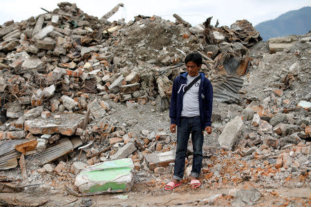 Ahmad, 43, a farmer, stands next to a pile of debris that used to be his home and was destroyed by an earthquake, in Balaroa neighbourhood, Palu, Central Sulawesi, Indonesia, October 11, 2018. REUTERS/Jorge Silva