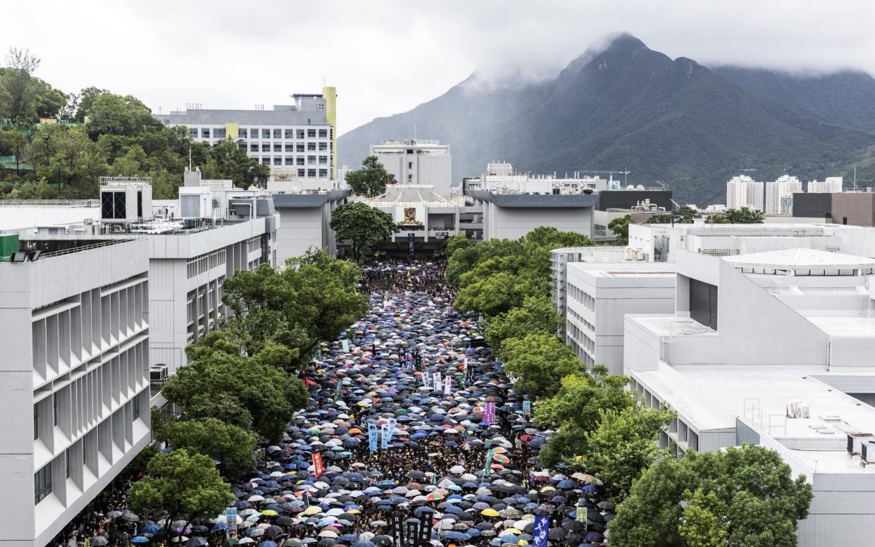 Students gather under umbrellas on the University Mall at the Chinese University of Hong Kong (CUHK) during a class boycott rally in Hong Kong - Bloomberg