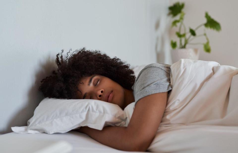 young black woman sleeping on white pillow under white sheets