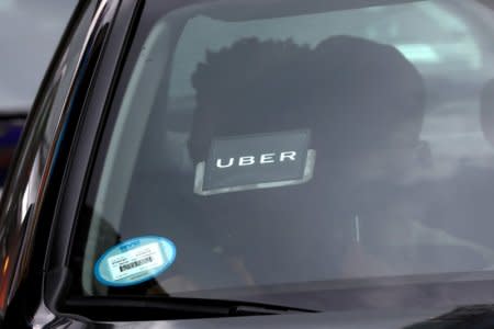 FILE PHOTO:    An Uber logo is seen on a car as it car drives through Times Square in New York City, New York, U.S., July 27, 2018. REUTERS/Mike Segar/File Photo